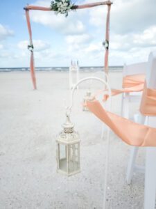 A person holding onto a lantern on the beach
