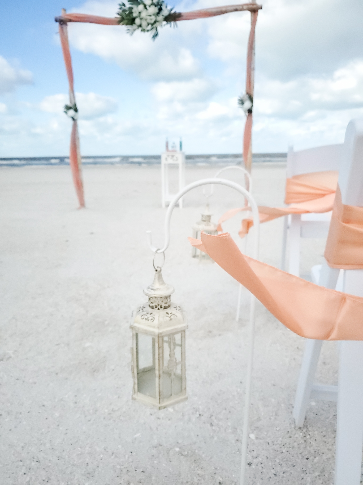A person holding onto a lantern on the beach