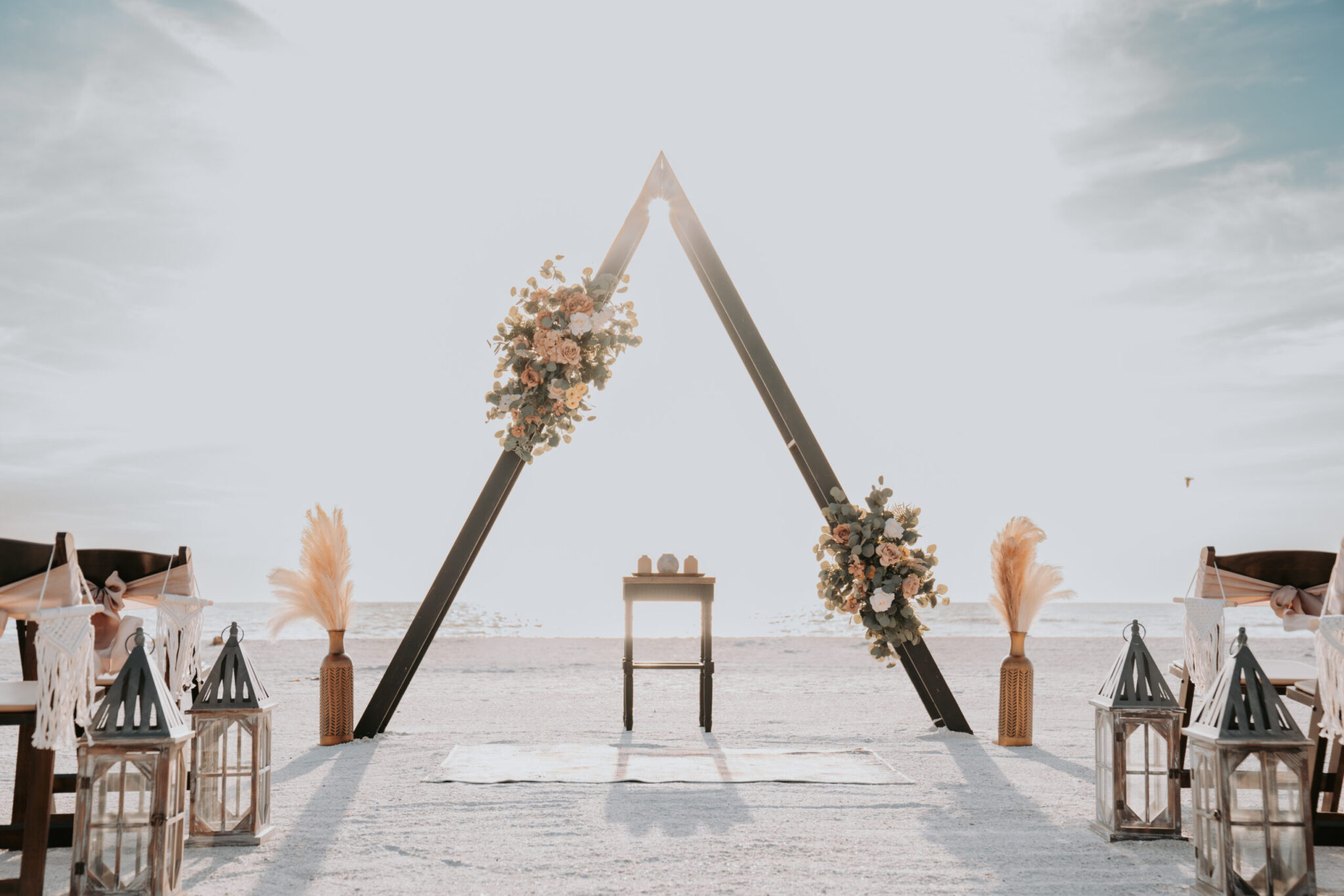 A chair and some flowers on the beach