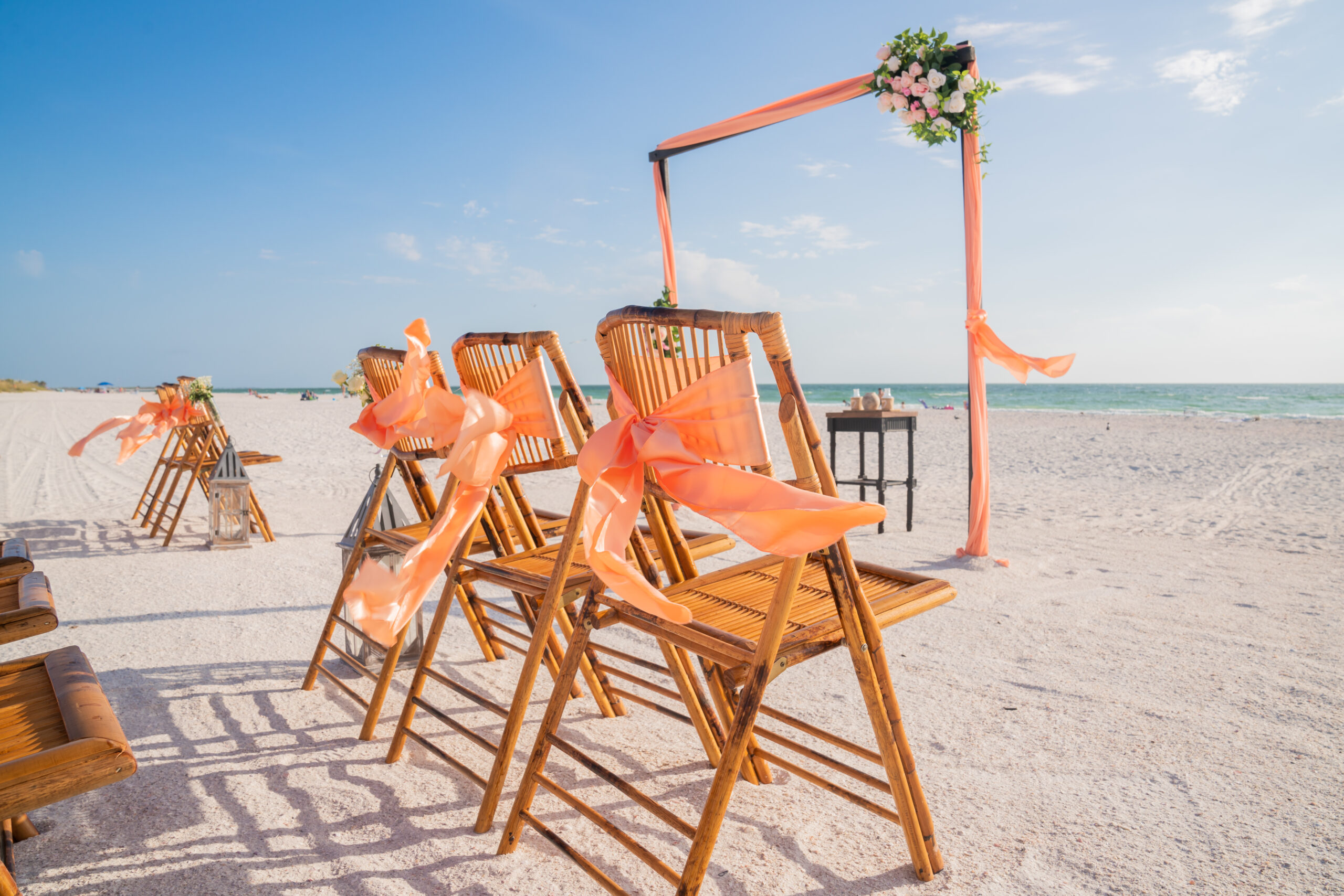 Beach wedding chairs with peach bows.