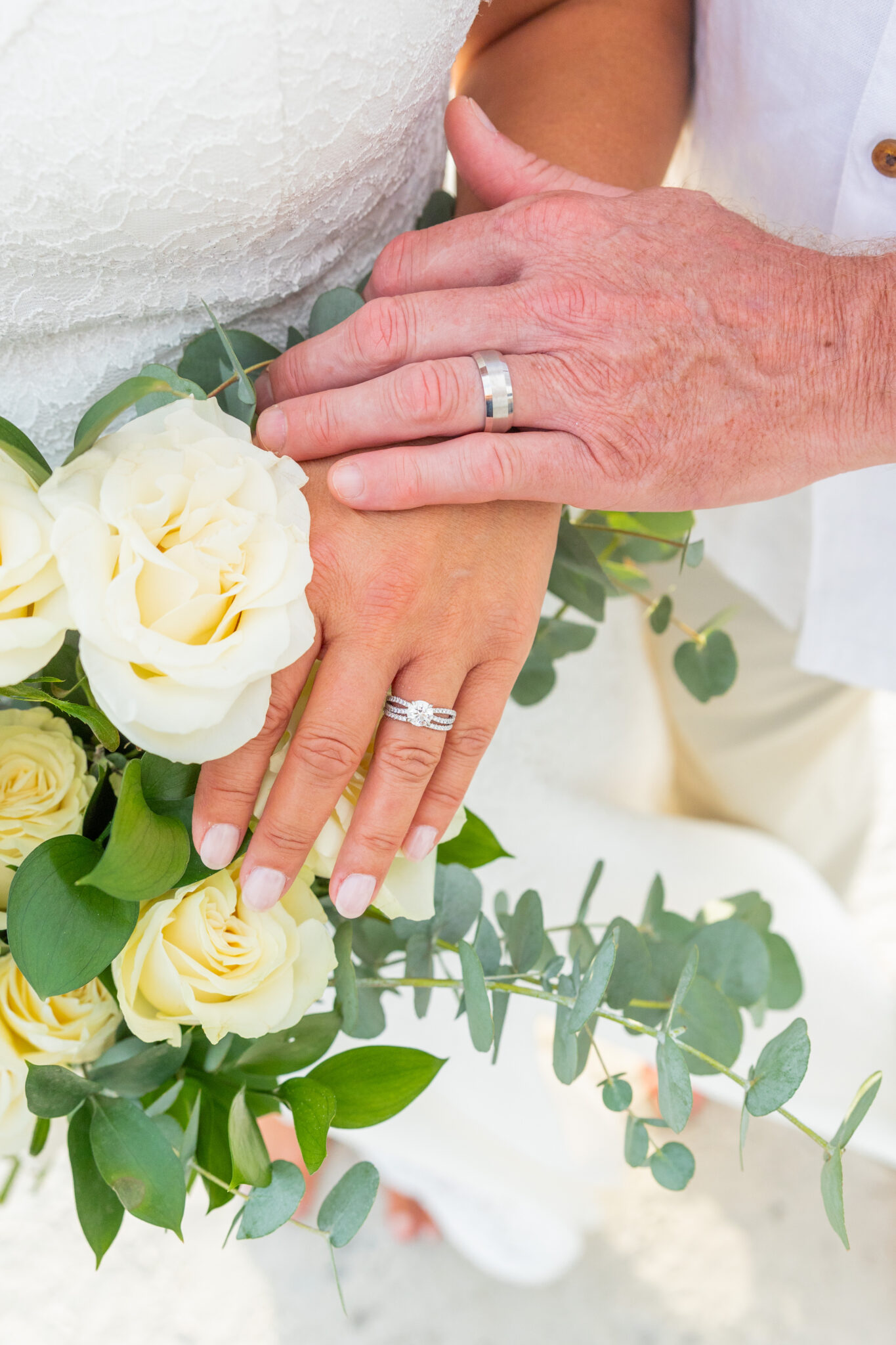 Photo of couple hands with rings and bouquet
